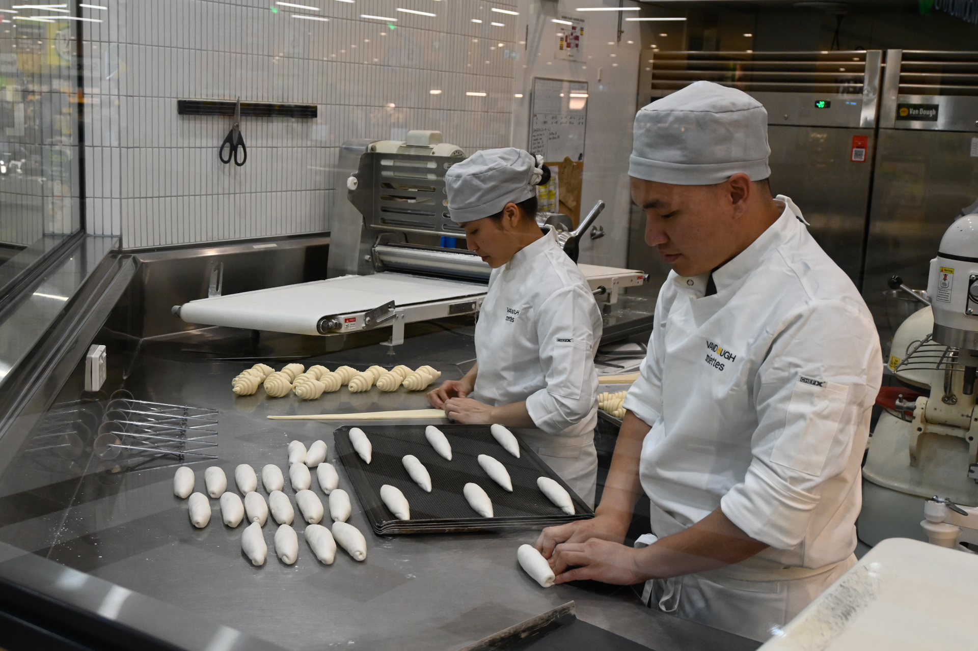 Bakers laminating butter into croissant dough
