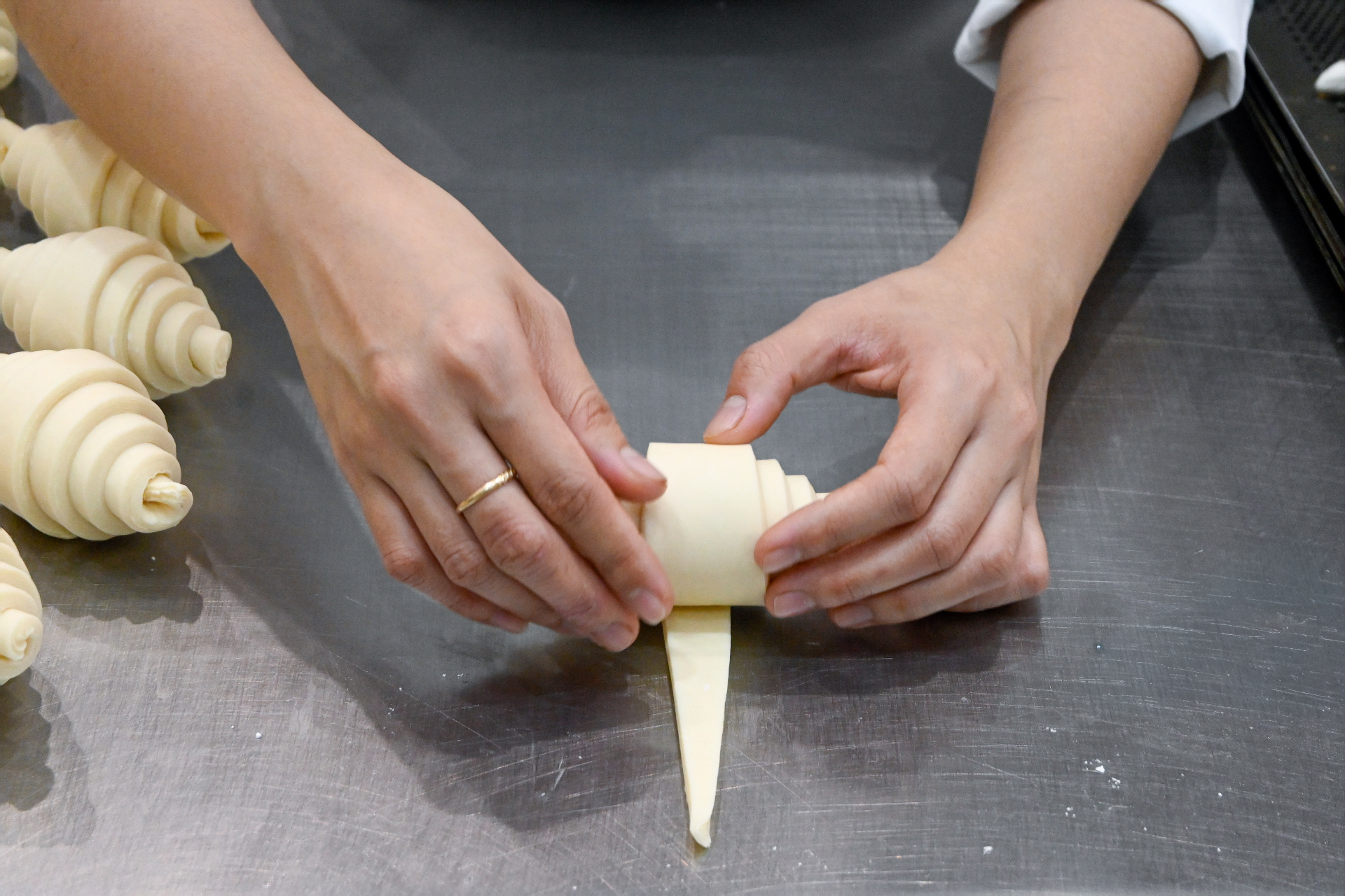 Baker hand-shaping laminated croissant dough in the Austral bakery